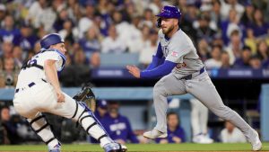 Chicago Cubs' Michael Busch, right, attempts to reach home past Los Angeles Dodgers catcher Will Smith, left, off a single hit by Alex Bregman during the fourth inning of a baseball game Friday, April 24, 2026, in Los Angeles. (Ryan Sun/AP)