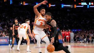 New York Knicks guard Miles McBride (2) drives past Atlanta Hawks guard CJ McCollum (3) during the first half in Game 2 of a first-round NBA playoffs basketball series, Monday, April 20, 2026, in New York. (Yuki Iwamura/AP)