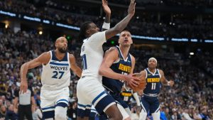 Denver Nuggets centre Nikola Jokic drives the lane as Minnesota Timberwolves centres Naz Reid and Rudy Gobert defend in the first half in Game 5 of a first-round NBA playoffs basketball series Monday, April 27, 2026, in Denver. (David Zalubowski/AP)