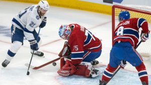 Montreal Canadiens goaltender Jakub Dobes stops a shot by Tampa Bay Lightning's Brayden Point as Canadiens' Mike Matheson defends during first period NHL playoff action in Montreal on Sunday, April 26, 2026. (THE CANADIAN PRESS/Christinne Muschi)