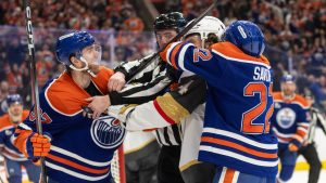 Vegas Golden Knights' Rasmus Andersson (4) roughs it up with Edmonton Oilers' Connor McDavid (97) and Matt Savoie (22) during second period NHL action, in Edmonton on Saturday April 4, 2026. (Jason Franson/CP)