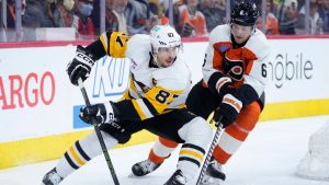 Pittsburgh Penguins' Sidney Crosby, left, tries to get past Philadelphia Flyers' Travis Sanheim during the third period of an NHL hockey game, Monday, Dec. 4, 2023, in Philadelphia. (Matt Slocum/AP)
