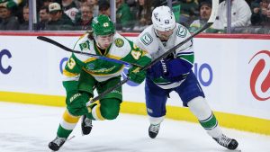Minnesota Wild defenceman Quinn Hughes, left, and Vancouver Canucks centre Elias Pettersson (40) compete for the puck during the second period of an NHL hockey game Thursday, April 2, 2026, in St. Paul, Minn. (Matt Krohn/AP)