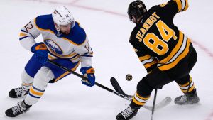 Boston Bruins left wing Tanner Jeannot (84) loses the blade to his stick while challenging Buffalo Sabres left wing Jordan Greenway (12) for the puck during the first period in Game 3 of a first-round NHL hockey Stanley Cup playoff series, Thursday, April 23, 2026, in Boston. (Charles Krupa/AP)