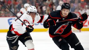 Carolina Hurricanes' Sebastian Aho (20) and Ottawa Senators' Tim Stützle (18) chase the puck during the first period in Game 1 of a first-round NHL Stanley Cup playoffs hockey series, Saturday, April 18, 2026, in Raleigh, N.C. (Karl DeBlaker/AP)