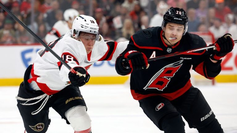 Carolina Hurricanes' Sebastian Aho (20) and Ottawa Senators' Tim Stützle (18) chase the puck during the first period in Game 1 of a first-round NHL Stanley Cup playoffs hockey series, Saturday, April 18, 2026, in Raleigh, N.C. (Karl DeBlaker/AP)