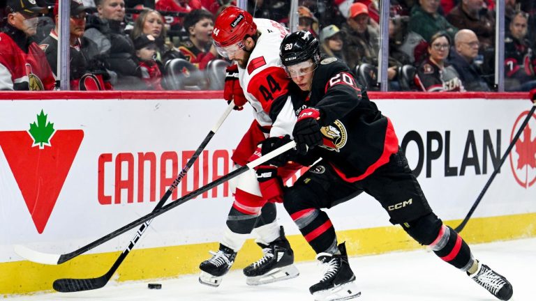 Carolina Hurricanes' Nicolas Deslauriers (44) tries to hold up Ottawa Senators' Fabian Zetterlund (20) as they fight for control of the puck during first period NHL hockey action in Ottawa, on Sunday, April 5, 2026. (Spencer Colby/THE CANADIAN PRESS)