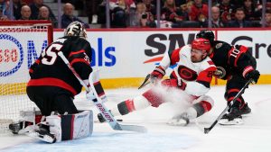 Ottawa Senators' Jordan Spence (10) checks Carolina Hurricanes' William Carrier (28), in front of goaltender Linus Ullmark (35) during first period NHL playoff hockey action in Ottawa, on Thursday, April 23, 2026. (Justin Tang/CP)