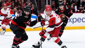 Ottawa Senators' Cameron Crotty (5) defends against Carolina Hurricanes' Nikolaj Ehlers (27) as he takes a shot, during first period NHL playoff hockey action in Ottawa, on Thursday, April 23, 2026. (Justin Tang/CP)