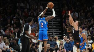 Oklahoma City Thunder guard Shai Gilgeous-Alexander (2) shoot a 3-pointer against Phoenix Suns guard Collin Gillespie (12) during the first half of Game 4 in a first-round NBA playoffs basketball series, Monday, April 27, 2026, in Phoenix. (Ross D. Franklin/AP)