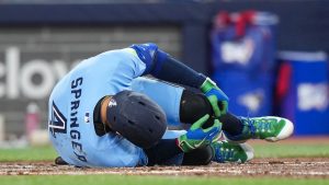 Toronto Blue Jays designated hitter George Springer falls to the ground after taking a foul ball off his foot while playing against he Minnesota Twins during third inning American League MLB baseball action in Toronto on Saturday, April 11, 2026. (Nathan Denette/CP)