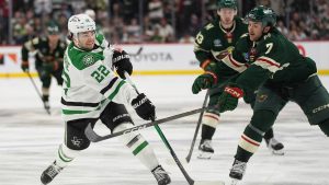 Dallas Stars center Mavrik Bourque (22) shoots as Minnesota Wild defenseman Brock Faber (7) defends during overtime of Game 3 in the first round of the NHL Stanley Cup hockey playoffs early morning Thursday, April 23, 2026, in St. Paul, Minn. (Abbie Parr/AP)