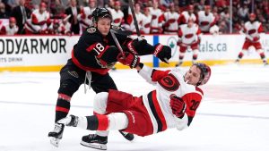 Ottawa Senators' Tim Stutzle (18) hits Carolina Hurricanes' Sebastian Aho (20) during third period NHL playoff hockey action in Ottawa, on Thursday, April 23, 2026. (Justin Tang/THE CANADIAN PRESS)