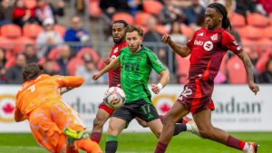 Toronto FC goalkeeper Luka Gavran (1) dives to make a save on Austin FC Jon Gallagher (17) as Toronto FC Zane Monlouis (12) joins the fray during first half MLS soccer action in Toronto on Saturday April 18, 2026. (Frank Gunn/CP)