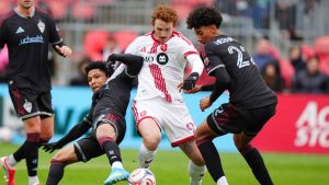 Toronto FC forward Josh Sargent, centre, moves with the ball between Colorado Rapids defender Jackson Travis, left, and Rapids defender Lucas Herrington (22) during first half MLS soccer action in Toronto. (Frank Gunn/THE CANADIAN PRESS)