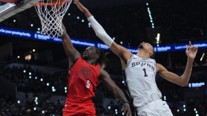 Portland Trail Blazers guard Jrue Holiday (5) goes to the basket as San Antonio Spurs centre Victor Wembanyama (1) defends during the first half in Game 5 of a first-round NBA playoffs basketball series in San Antonio, Tuesday, April 28, 2026. (Eric Gay/AP)