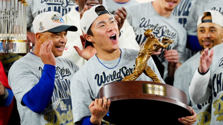 Los Angeles Dodgers pitcher Yoshinobu Yamamoto (18) lifts the World Series MVP trophy as the Dodgers celebrate after defeating the Toronto Blue Jays in Game 7 World Series playoff MLB baseball action in Toronto early Sunday, Nov. 2, 2025. (Frank Gunn/CP)
