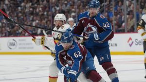 Colorado Avalanche left wing Artturi Lehkonen, front, collects the puck as defenseman Josh Manson, back right, checks Vegas Golden Knights center Tomas Hertl during the second period in Game 2 of the Western Conference finals NHL hockey Stanley Cup playoff series Friday, May 22, 2026, in Denver. (AP Photo/David Zalubowski)