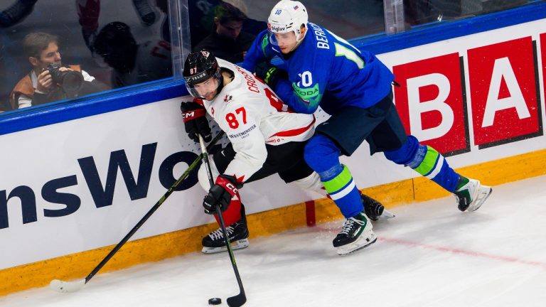 Canada's Sidney Crosby, left, vies for the puck against Slovenia's Miha Bericic, right, during a preliminary round game between Canada and Slovenia at the men's ice hockey world championship in Fribourg, Switzerland, Friday May 22, 2026. (Salvatore Di Nolfi/Keystone via AP)