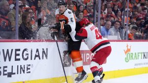 Philadelphia Flyers' Travis Sanheim, left, is hit by Carolina Hurricanes' Jordan Martinook, right, during the first period of Game 4 in a second-round NHL hockey Stanley Cup playoff series Saturday, May 9, 2026, in Philadelphia. (AP Photo/Matt Slocum)