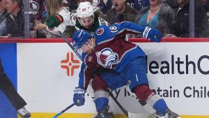 Colorado Avalanche center Jack Drury, front, checks Minnesota Wild defenseman Quinn Hughes in the second period of Game 2 of an NHL hockey Stanley Cup second-round playoff series Tuesday, May 5, 2026, in Denver. (David Zalubowski/AP)