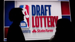 NBA basketball draft prospect Johnny Furphy, left, looks at the draft lottery order in front of a draft lottery sign before the draft lottery in Chicago, Sunday, May 12, 2024. (Nam Y. Huh/AP)