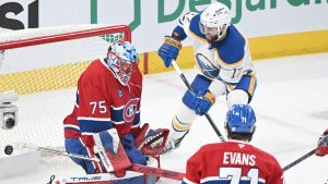 Buffalo Sabres' Jason Zucker scores against Montreal Canadiens goaltender Jakub Dobes as Canadiens' Jake Evans defends during first period, second round, Game 6, NHL playoff action in Montreal on Saturday, May 16, 2026. (THE CANADIAN PRESS/Graham Hughes)