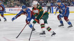 Minnesota Wild defenseman Quinn Hughes (43) skates with the puck while Colorado Avalanche defenseman Cale Makar (8) defends during the first period of an NHL hockey game Sunday, Dec. 21, 2025, in St. Paul, Minn. (Bailey Hillesheim/AP)