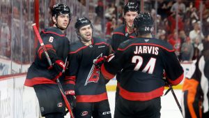 Carolina Hurricanes' Logan Stankoven (22) celebrates after his second goal with teammates Mike Reilly (6), Andrei Svechnikov, back right, and Seth Jarvis (24) during the second period of Game 1 of an NHL hockey Stanley Cup second-round playoff series against the Philadelphia Flyers in Raleigh, N.C., Saturday, May 2, 2026. (Karl DeBlaker/AP)