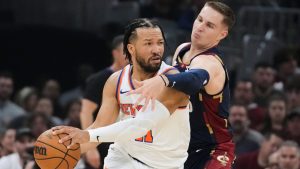 Cleveland Cavaliers guard Sam Merrill, right, defends against New York Knicks guard Jalen Brunson (11) during the first half of Game 4 in the Eastern Conference finals NBA basketball playoffs series in Cleveland, Monday, May 25, 2026. (AP Photo/Sue Ogrocki)