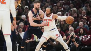 Cleveland Cavaliers forward Dean Wade (32) defends against New York Knicks guard Jalen Brunson (11) during the first half of Game 4 in the Eastern Conference finals NBA basketball playoffs series in Cleveland, Monday, May 25, 2026. (AP Photo/Sue Ogrocki)