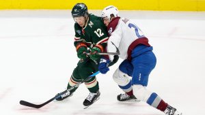 Minnesota Wild left wing Matt Boldy (12) and Colorado Avalanche center Nathan MacKinnon (29) vie for the puck during the first period of an NHL hockey game, Tuesday, March 11, 2025, in St. Paul, Minn. (Ellen Schmidt/AP)