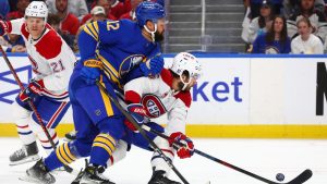 Montreal Canadiens center Alex Newhook, right, is checked by Buffalo Sabres left wing Jordan Greenway (12) during the first period in Game 5 of a second-round NHL hockey Stanley Cup playoff series, Thursday, May 14, 2026, in Buffalo, N.Y. (AP Photo/Jeffrey T. Barnes)