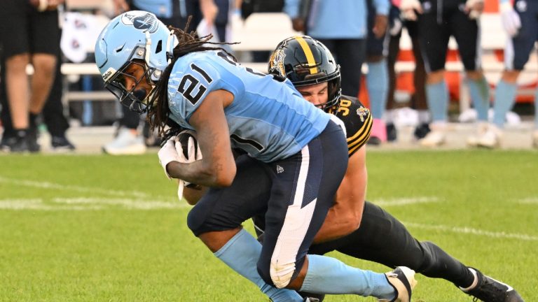 Toronto Argonauts' running back Spencer Brown (21) is tackled by Hamilton Tiger-Cats' linebacker Devin Veresuk (49) during second half CFL football action in Toronto, Saturday, Oct. 4, 2025. (Jon Blacker/CP)