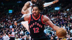 Toronto Raptors' Collin Murray-Boyles (12) drives past New York Knicks' Guerschon Yabusele (28) during first half NBA Cup basketball action in Toronto, on Tuesday, Dec. 9, 2025. (Sammy Kogan/CP)