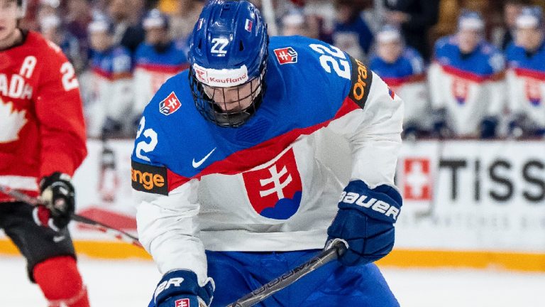 Slovakia's Adam Goljer (22) is defended by Canada's Kashawn Aitcheson (2) and Ben Danford (14) during third period IIHF World Junior Championship quarterfinal hockey action, in Minneapolis, Minn., on Friday, January 2, 2026. THE CANADIAN PRESS/Christopher Katsarov