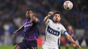 Vancouver Whitecaps forward Brian White (24) and Los Angeles Galaxy defender Emiro Garces (25) chase the ball during the first half of an MLS soccer match Saturday, May 2, 2026, in Carson, Calif. (AP Photo/Jae C. Hong)