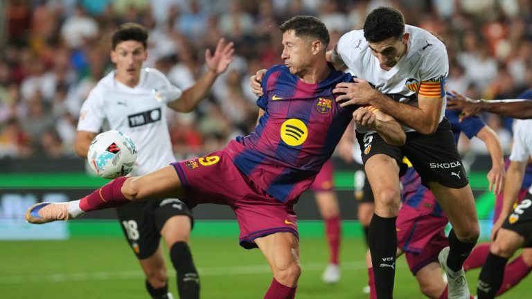 Barcelona's Robert Lewandowski, left, attempts a shot on goal challenged by Valencia's Cesar Tarrega during the Spanish La Liga soccer match between Valencia and FC Barcelona in Valencia, Spain, Saturday, May 23, 2026. (AP Photo/Alberto Saiz)