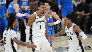 San Antonio Spurs guard Stephon Castle (5), forward Victor Wembanyama (1) and guard Devin Vassell (24) react after a basket against the Oklahoma City Thunder during the first half of Game 4 in the Western Conference finals NBA basketball playoffs series in San Antonio, Sunday, May 24, 2026. (AP Photo/Eric Gay)