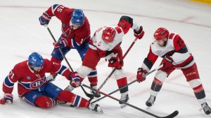 Carolina Hurricanes' Jackson Blake, Logan Stankoven and Montreal Canadiens' Alex Newhook dig for the puck under Canadiens' Jake Evans during second period of Game 3 of the NHL Eastern Conference final Stanley Cup playoff series action in Montreal on Monday, May 25, 2026. (Christinne Muschi/CP)