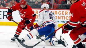 Carolina Hurricanes' Jordan Staal (11) passes the puck under Montréal Canadiens' Mike Matheson during the second period of an NHL game in Raleigh, N.C., Sunday, March 29, 2026. (AP/Karl DeBlaker)