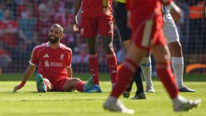Liverpool's Mohamed Salah smiles as he sits on the pitch after getting injured during the English Premier League soccer match between Liverpool and Crystal Palace in Liverpool, England, Saturday, April 25, 2026. (AP Photo/Ian Hodgson)