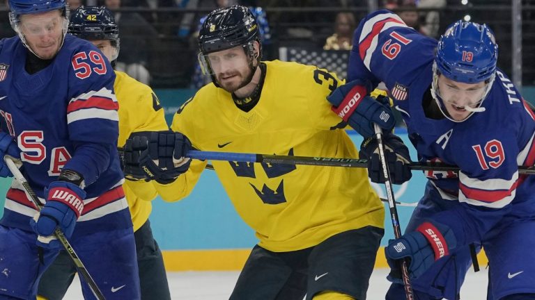 Sweden's Oliver Ekman-Larsson (3) tries to keep United States' Matthew Tkachuk (19) away from the net during the third period of a men's ice hockey quarterfinal game at the 2026 Winter Olympics, in Milan, Italy, Wednesday, Feb. 18, 2026. (AP Photo/Hassan Ammar)