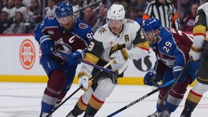 Vegas Golden Knights center Jack Eichel strugles to move the puck as Colorado Avalanche left wing Gabriel Landeskog, left, and center Nathan MacKinnon, right, defend during the second period in Game 1 of the Western Conference finals NHL hockey Stanley Cup playoff series Wednesday, May 20, 2026, in Denver. (David Zalubowski/AP)