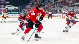 Czech Republic's Jakub Flek, left, and Canada's Evan Bouchard in action during a preliminary round game between Czech Republic and Canada at the men's ice hockey world championship in Fribourg, Switzerland, Tuesday May 26, 2026. (Anthony Anex/Keystone via AP)