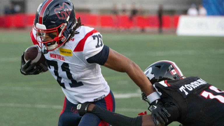 Montreal Alouettes ball carrier fights off Ottawa Redblacks' Roterius "Ro" Torrence during first half CFL football action in Montreal Friday. May 22, 2026. (Peter McCabe/CP)
