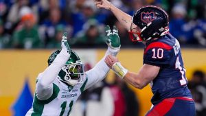 Montreal Alouettes quarterback Davis Alexander (10) unloads the ball before getting hit by Saskatchewan Roughriders' Malik Carney (11) during second half CFL football action at the 112th Grey Cup. (Frank Gunn/THE CANADIAN PRESS)