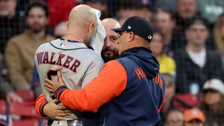 Houston Astros' Christian Walker, left, is assisted by coaches after getting hit in the head by a pitch during the ninth inning of a baseball game against the Boston Red Sox, Saturday, May 2, 2026, in Boston. (Mark Stockwell/AP)