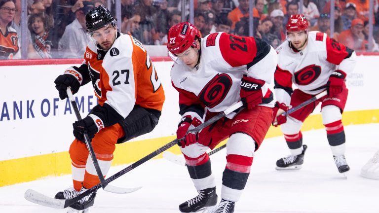 Carolina Hurricanes centre Logan Stankoven, centre, handles the puck in front of Philadelphia Flyers left winger Noah Cates, left, during the second period of an NHL hockey game, Monday, April 13, 2026, in Philadelphia. (Chris Szagola/AP)