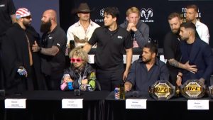 Josh Hokit and Ilia Topuria yell at each other at a UFC press conference while being separated by security.